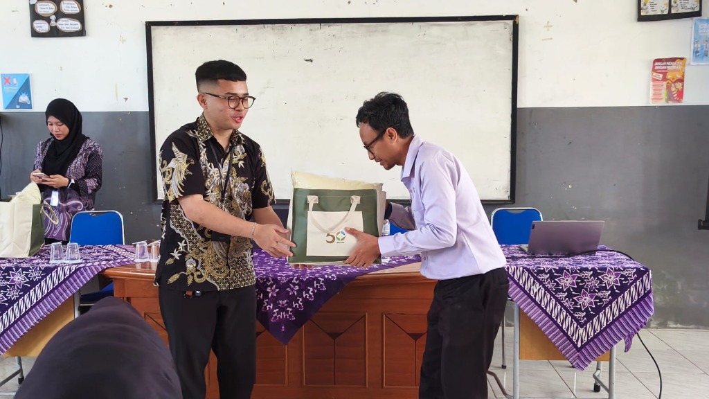 Perwakilan PT Medion Farma Jaya Tbk menyerahkan souvenir cenderamata kepada Wakasek Humas Hubin Setia Permana, S.Pd.