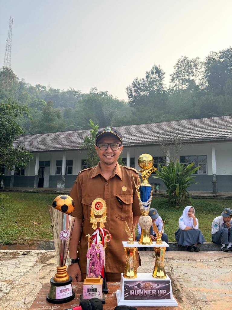 Guru pembina dan tim kesiswaan menyerahkan piala kejuaraan futsal kepada perwakilan tim Bumarang