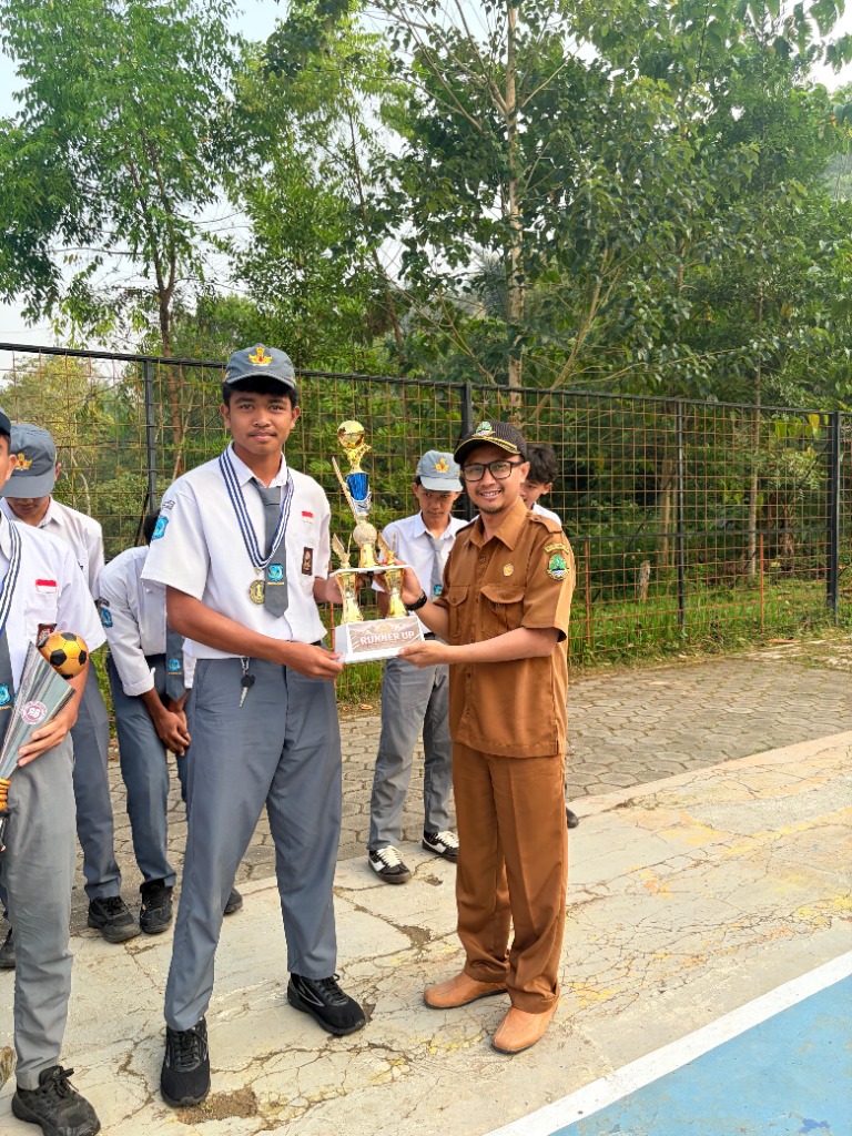Guru pembina menyerahkan trofi Runner Up kepada perwakilan tim Warriors di lapangan SMKN 1 Rongga