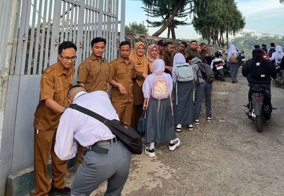 Guru dan tenaga kependidikan SMKN 1 Rongga menyambut siswa di gerbang sekolah dalam kegiatan Sapa Pagi