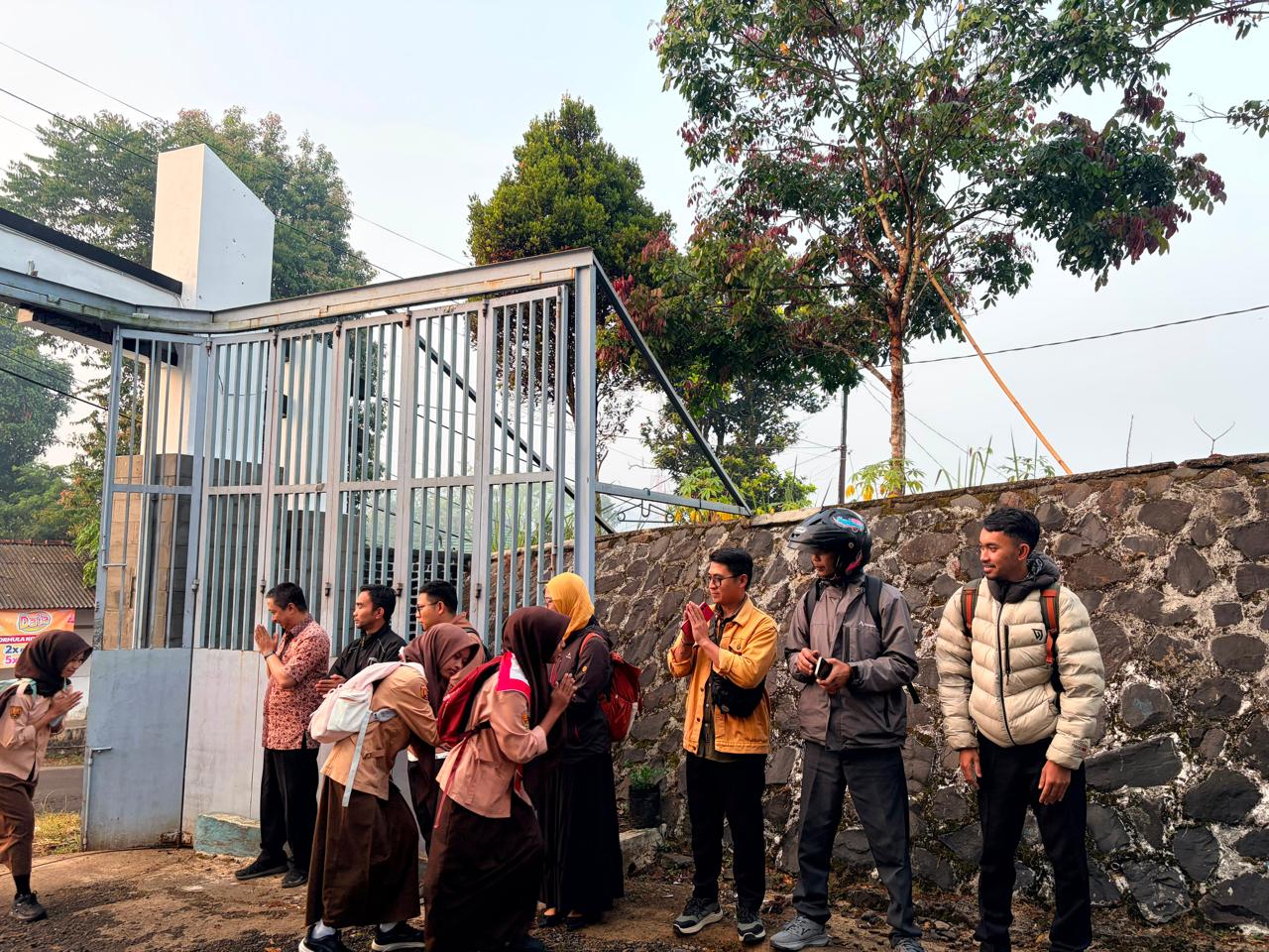Siswa menyalami guru piket saat tiba di sekolah