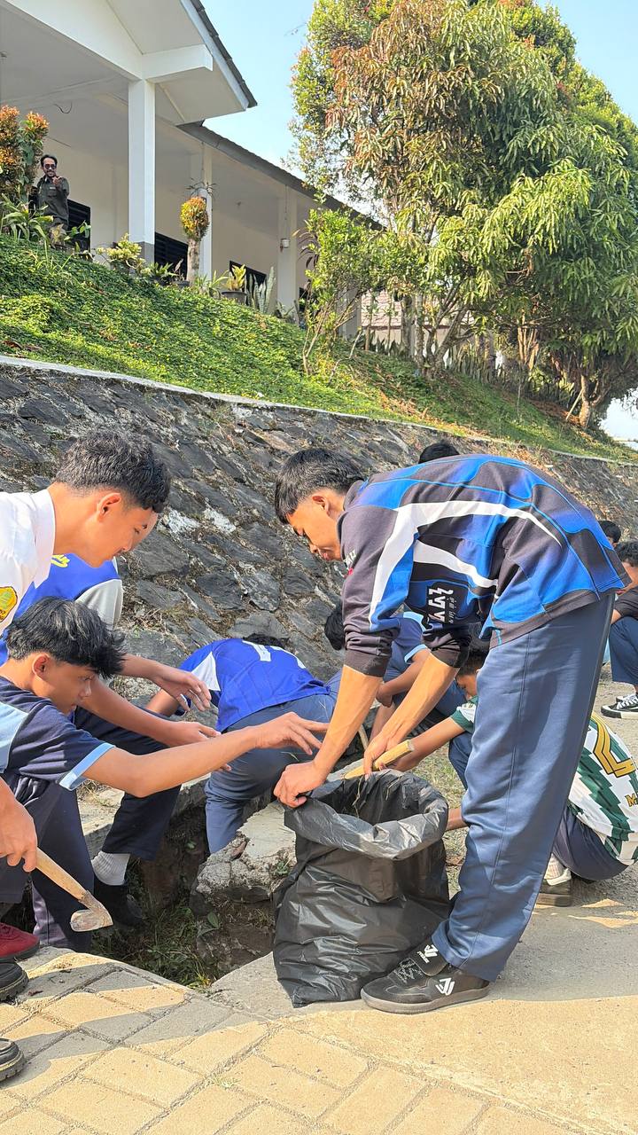 Siswa-siswa SMKN 1 Rongga membersihkan saluran drainase air di bawah tebing penahan tanah sekolah