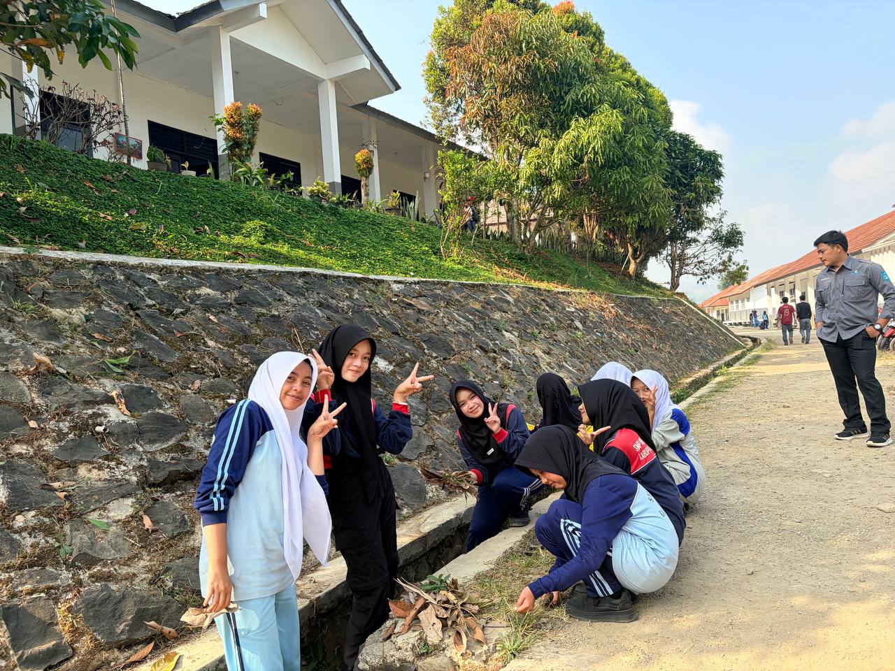Keceriaan siswi-siswi SMKN 1 Rongga saat bergotong royong membersihkan pekarangan dan tanaman di bawah tebing sekolah