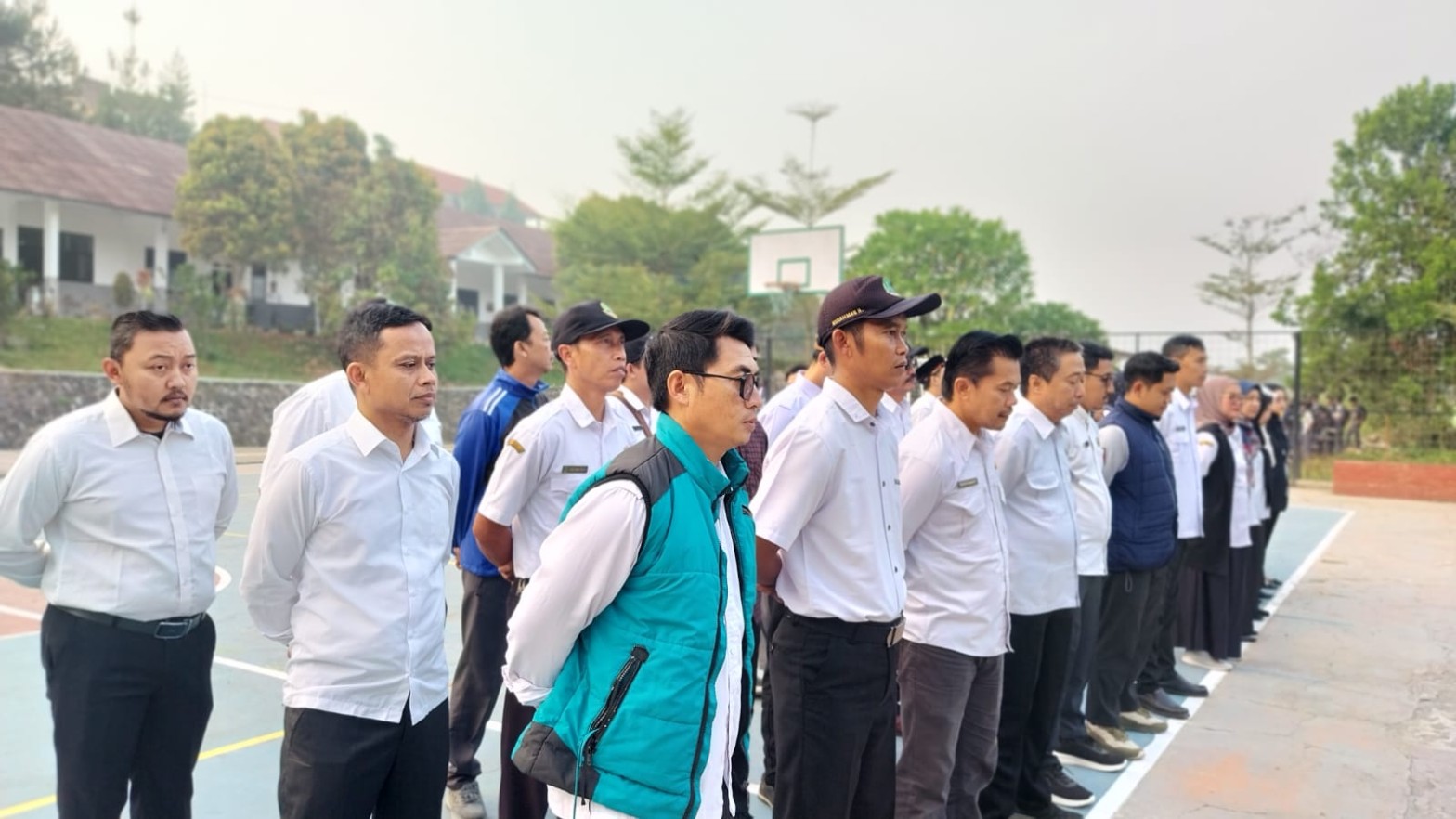 Barisan rapi guru SMKN 1 Rongga mengikuti apel pembinaan di lapangan dengan latar gedung sekolah
