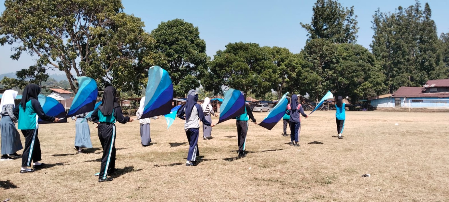 Colour guard drumband SMKN 1 Rongga berlatih formasi dengan bendera biru gradasi di Lapangan Kecamatan Rongga