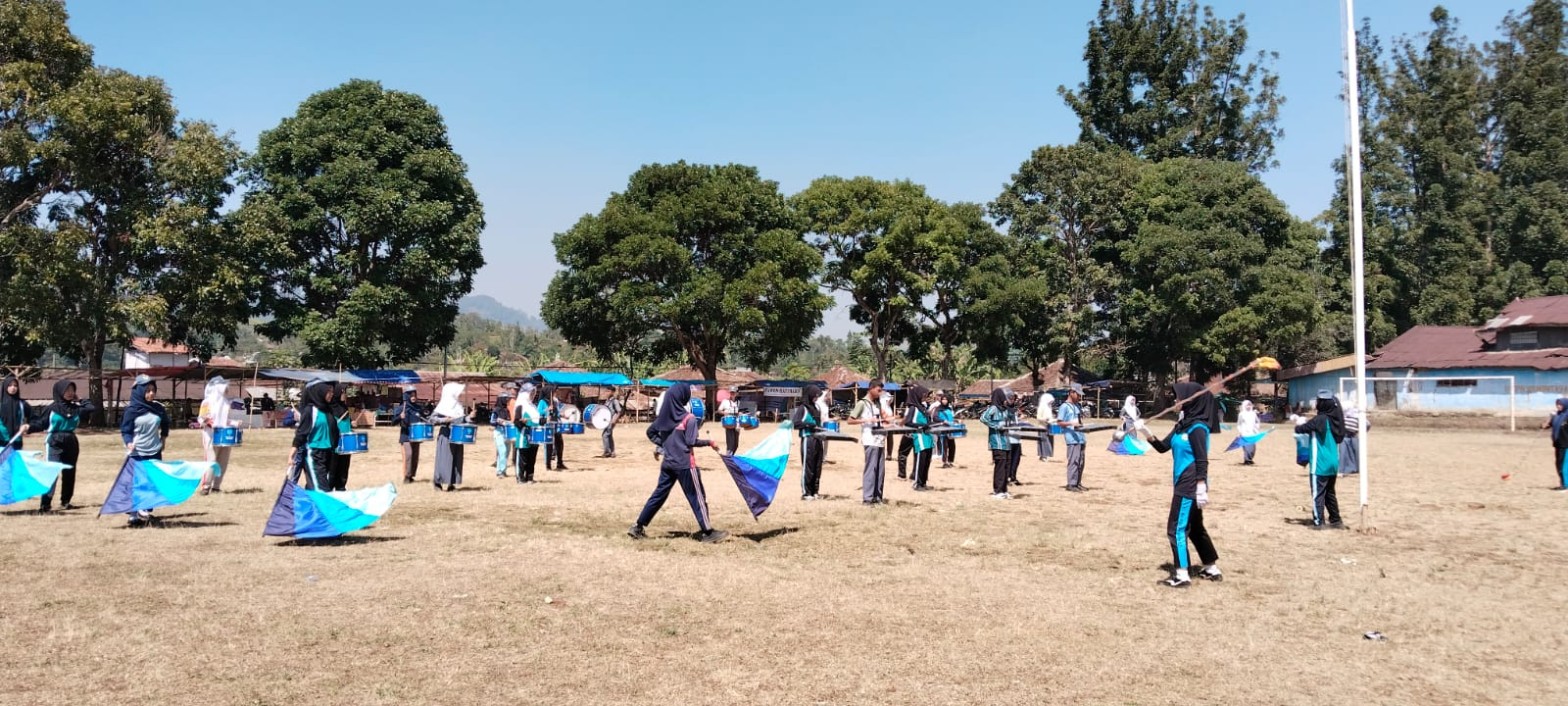 Formasi lengkap drumband SMKN 1 Rongga dengan colour guard, perkusi, dan bellyra berlatih di Lapangan Kecamatan Rongga