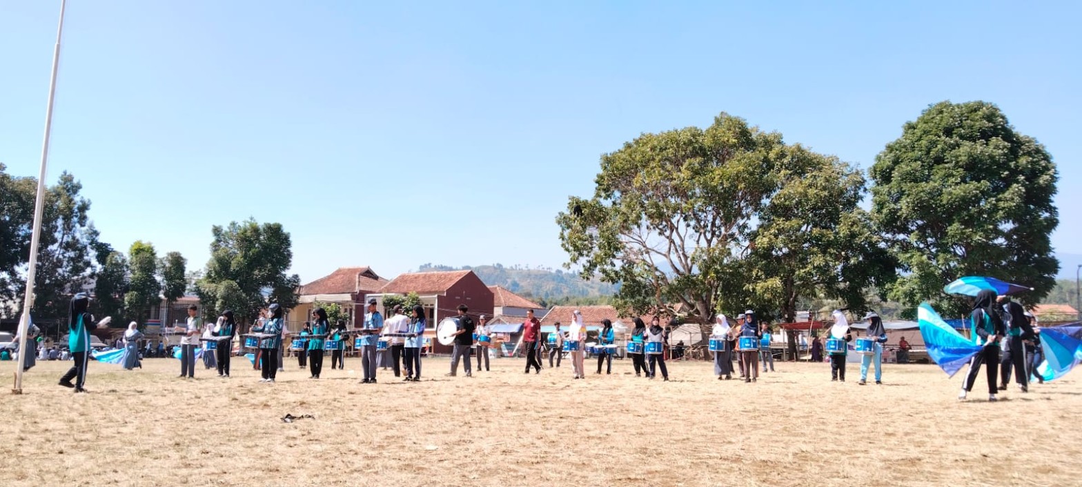 Formasi lebar drumband SMKN 1 Rongga memenuhi Lapangan Kecamatan Rongga dengan colour guard, perkusi, dan bellyra tersebar