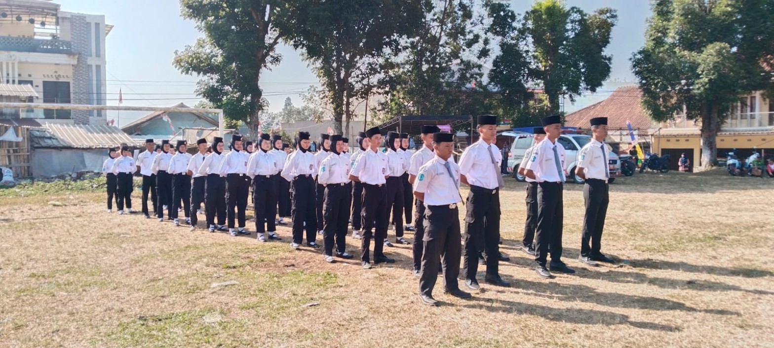 Dirigen memandu tim Paduan Suara SMKN 1 Rongga's Choir menyanyi dengan gerakan tangan di depan mikrofon berlatar umbul-umbul