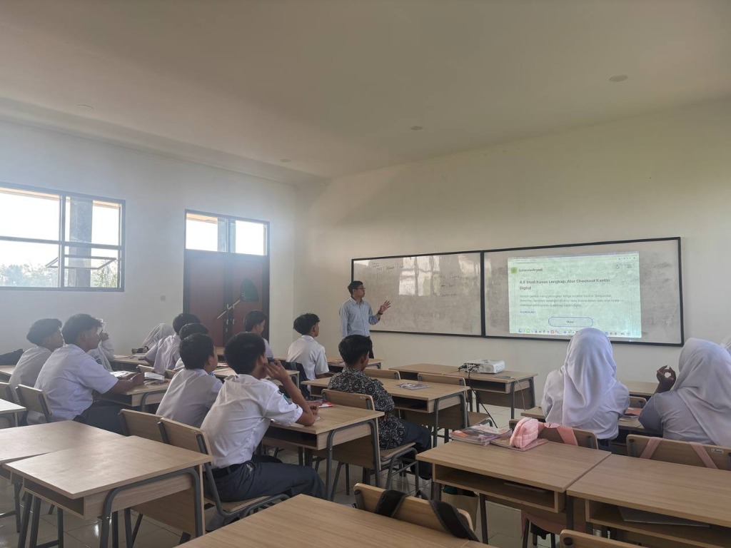 Guru Informatika SMKN 1 Rongga membedah studi kasus alur checkout kantin digital di depan layar proyektor