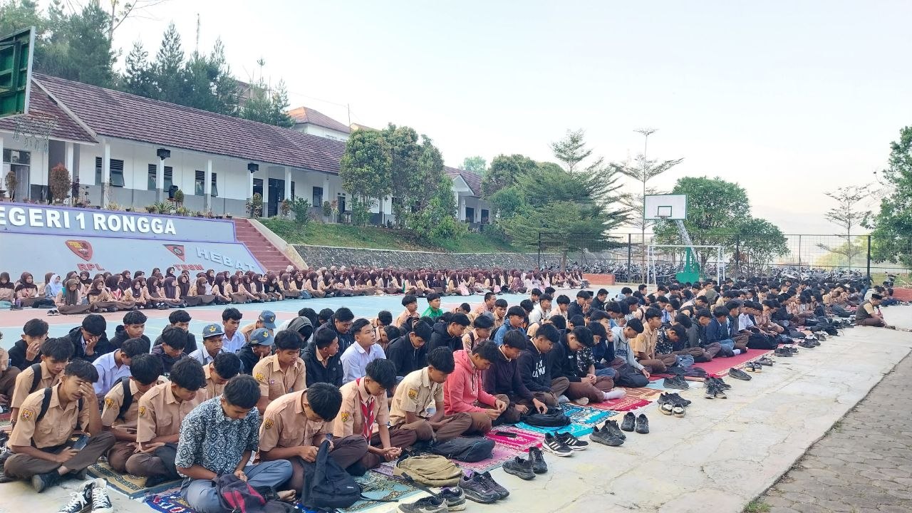 Siswa putra SMKN 1 Rongga berbaris rapat di dekat spanduk sekolah mengikuti Shalat Dhuha berjamaah