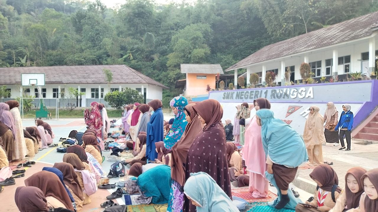 Siswi SMKN 1 Rongga berdiri berjamaah mengikuti Shalat Dhuha di lapangan sekolah dengan latar pepohonan hijau