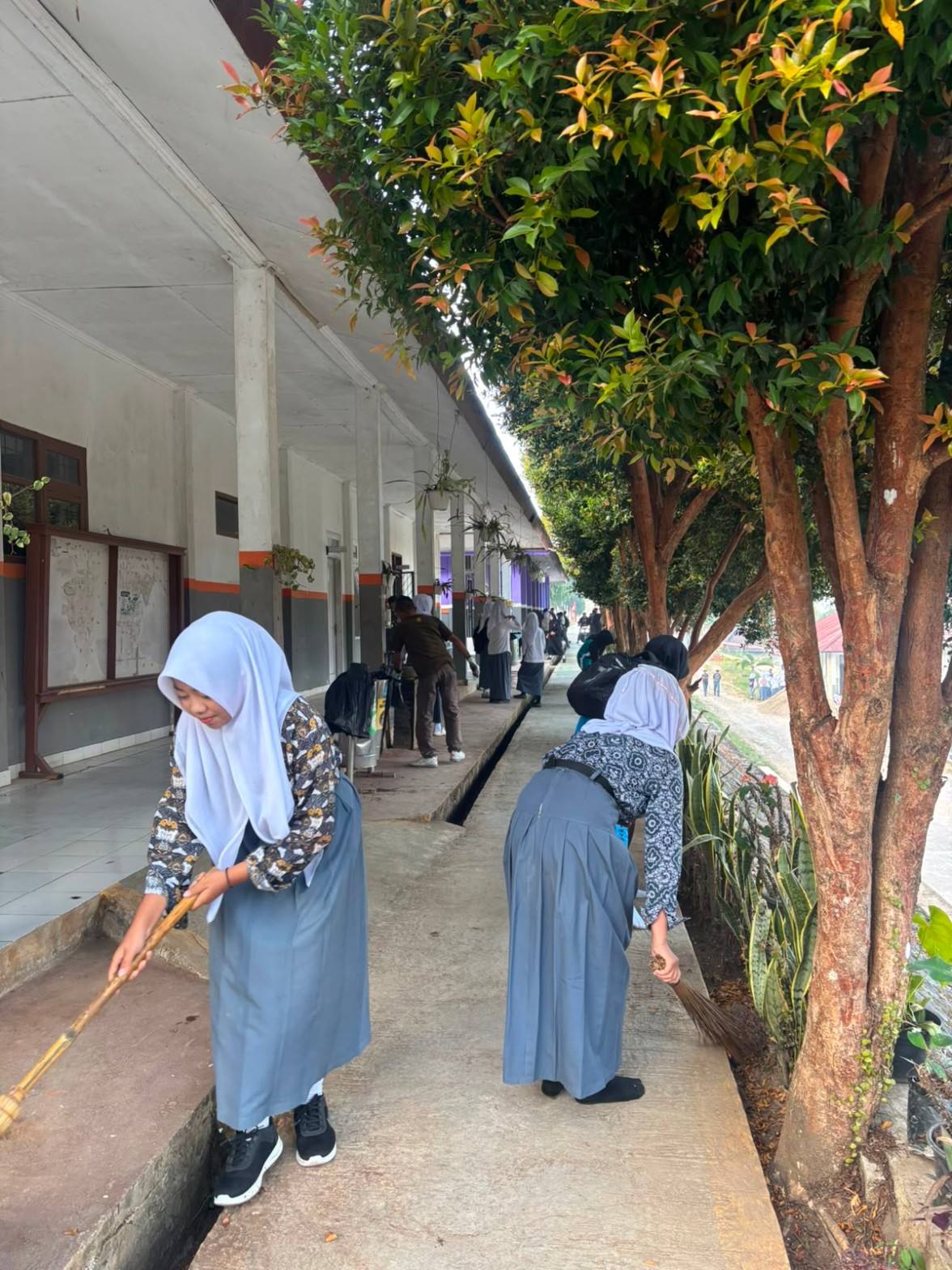 Perspektif panjang koridor SMKN 1 Rongga dengan siswa menyapu serentak di kedua sisi