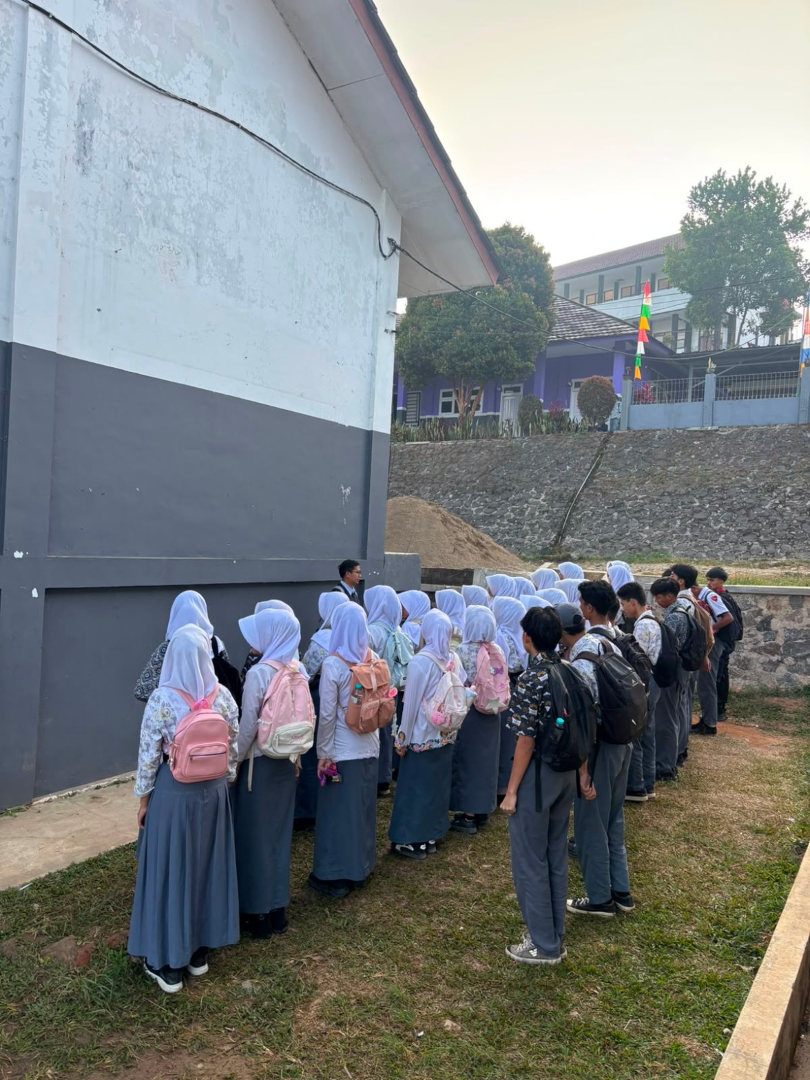 Suhendar Aryadi S.Pd. Gr. memimpin briefing kelas XII RPL 1 sebelum kegiatan Kamis Bersih di halaman sekolah