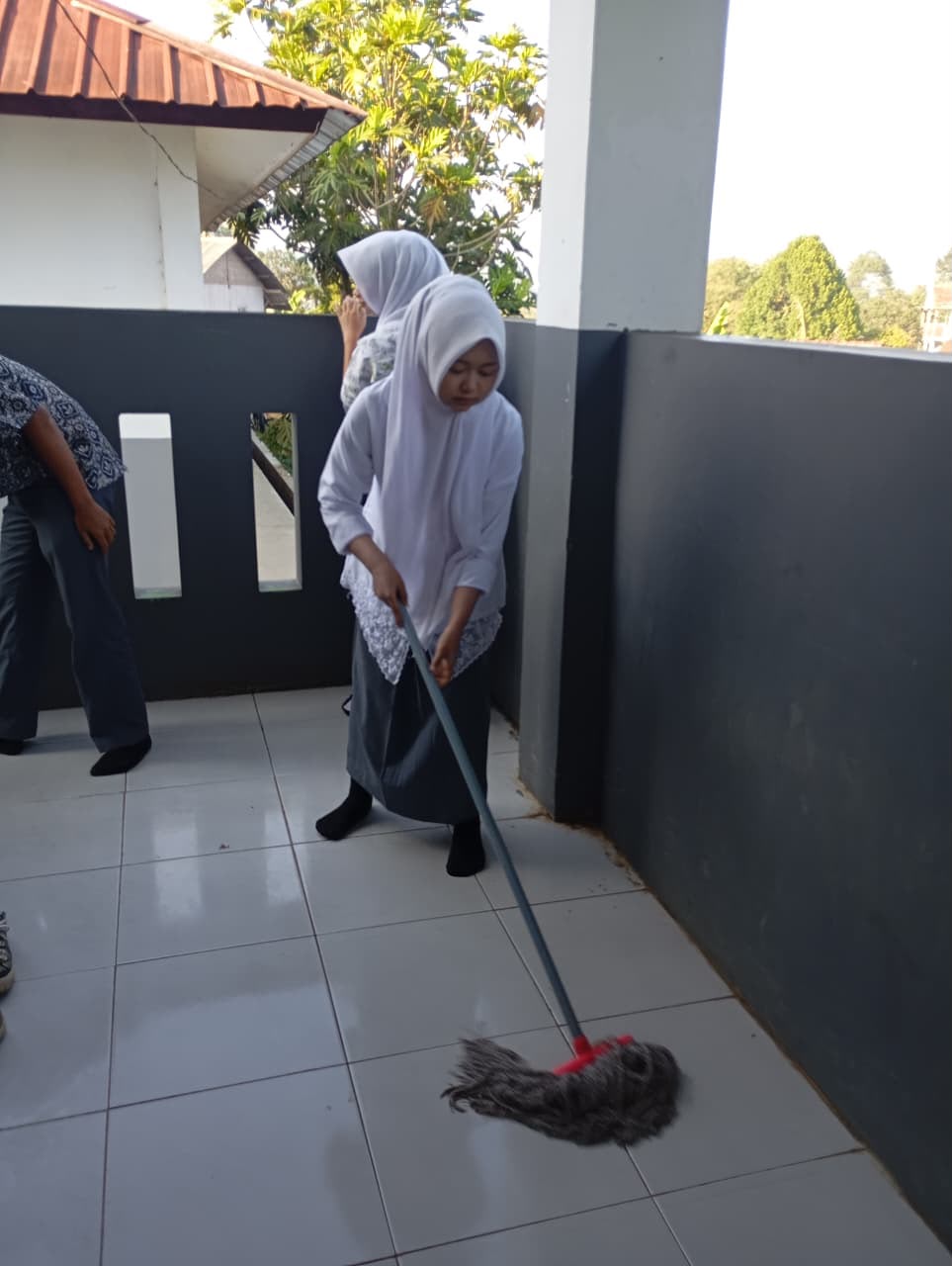 Siswi SMKN 1 Rongga mengepel lantai kelas dengan pel basah pada kegiatan Kamis Bersih