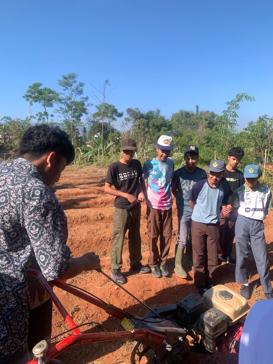 Siswa SMKN 1 Rongga antusias menyimak arahan pengoperasian gas dan tarikan mesin kultivator di bawah sinar matahari pagi