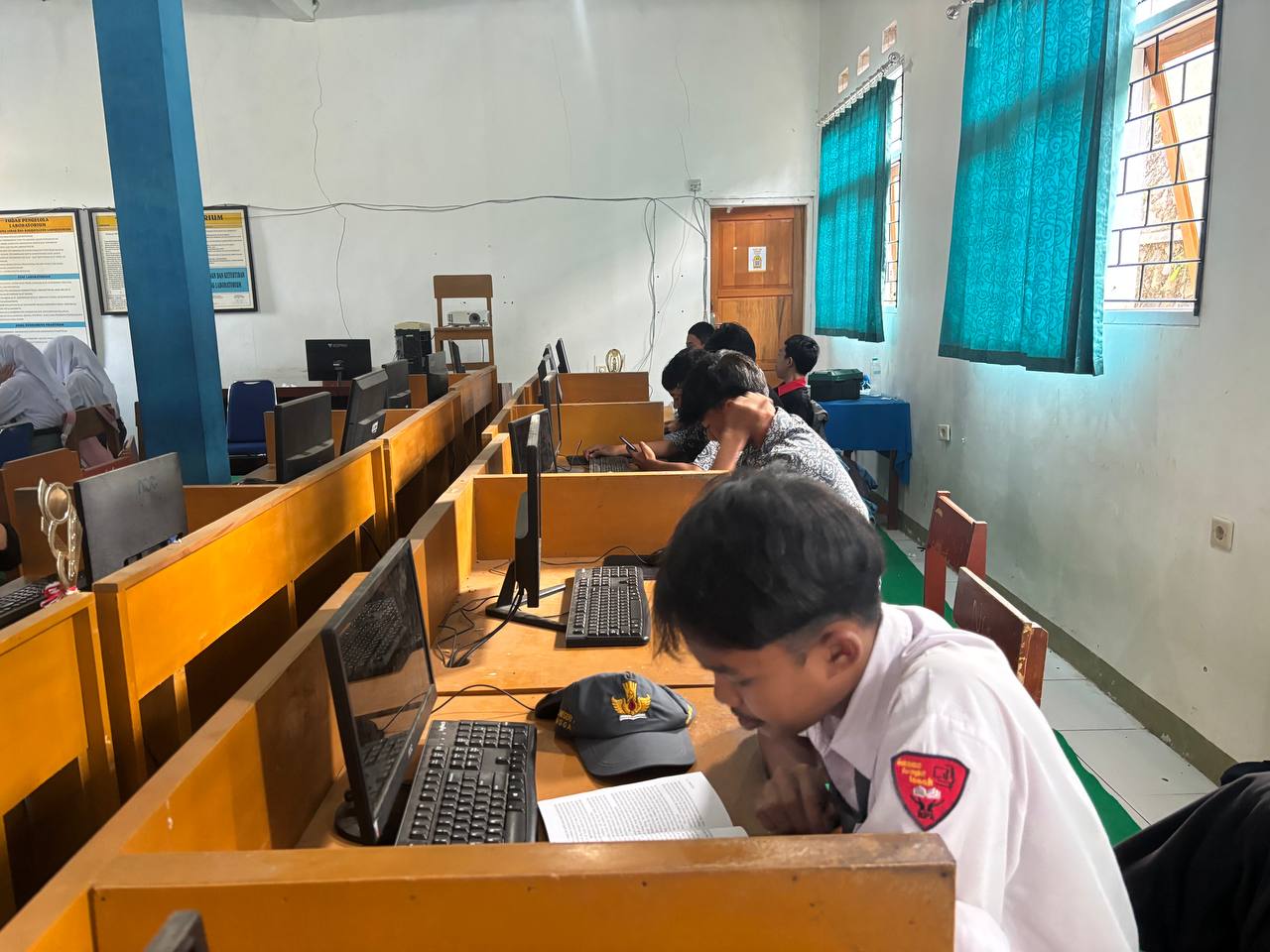 Siswa SMKN 1 Rongga tampak khusyuk dan konsentrasi membaca buku di meja komputer laboratorium