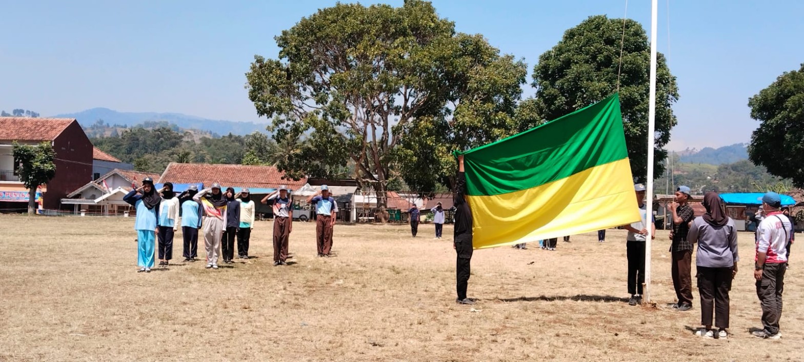 Tim Paskibra SMKN 1 Rongga berlatih pengibaran bendera hijau-kuning di tiang utama lapangan sementara anggota lain hormat