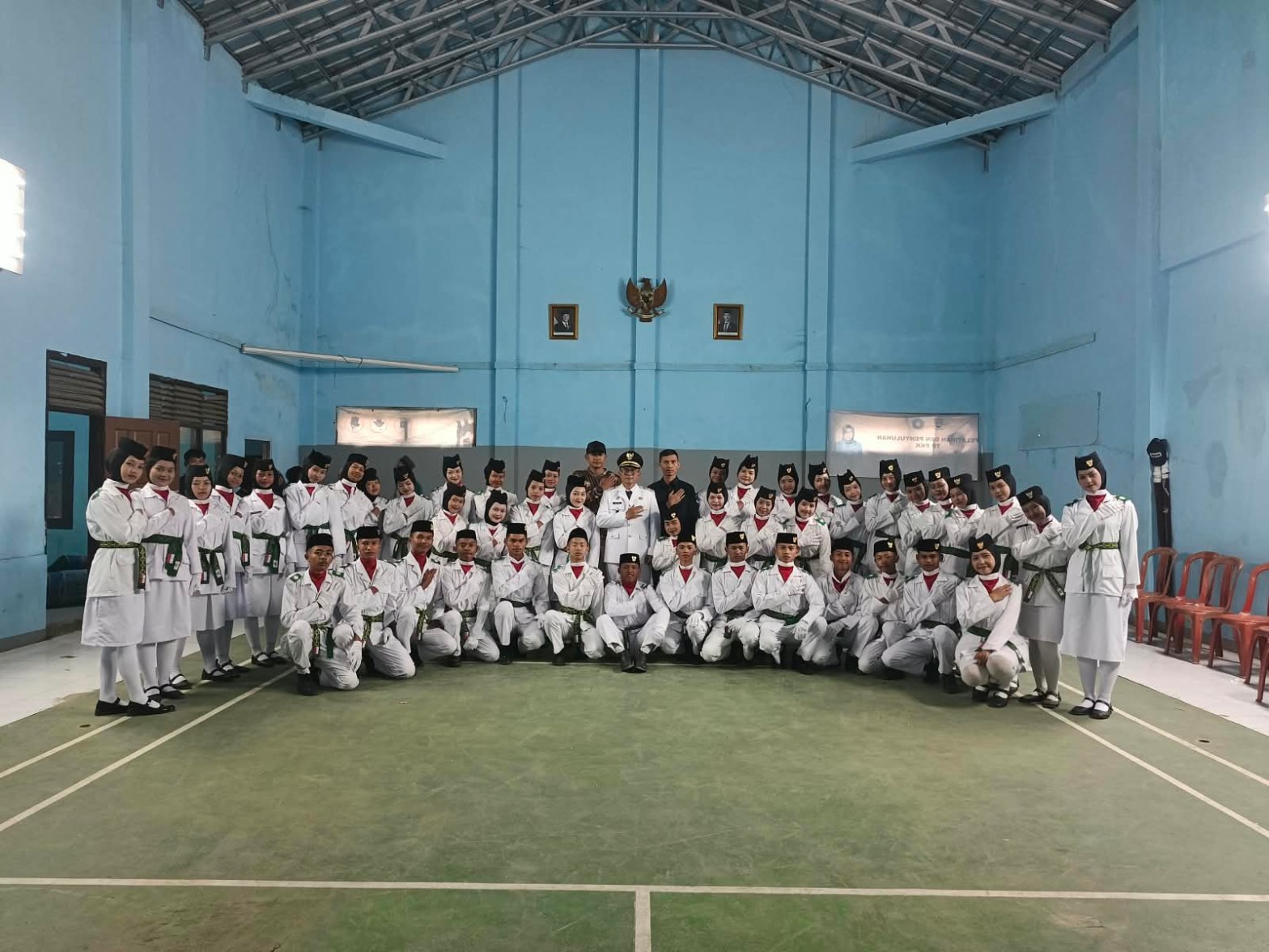 Barisan petugas pengibar bendera berdiri rapi dan disiplin menyaksikan prosesi pemasangan atribut di gedung olahraga