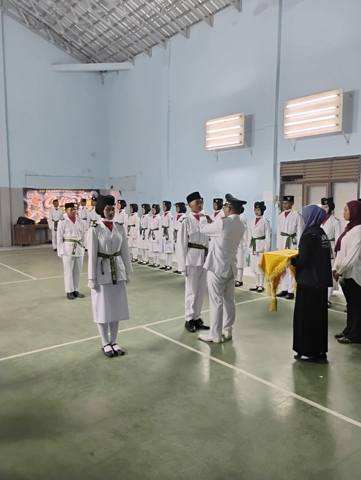 Seluruh petugas pengibar bendera berpose bersama pejabat di dalam gedung olahraga usai prosesi pengukuhan