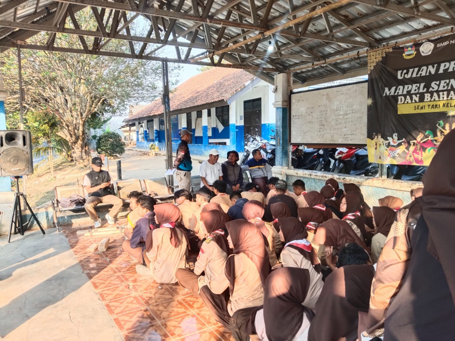 Peserta Pramuka duduk berkelompok di area terbuka pada pagi hari bersiap berangkat mengikuti longmarch dan hiking beregu