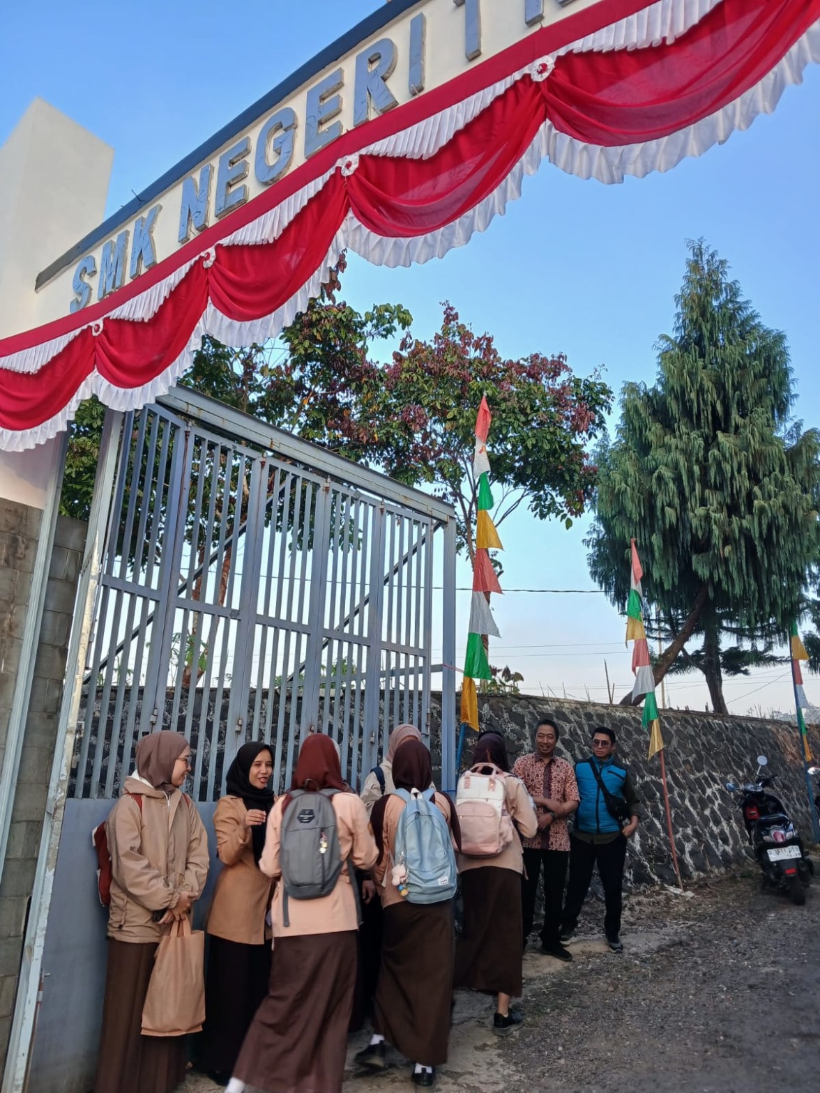Rombongan siswi SMKN 1 Rongga berjalan memasuki gerbang sekolah disambut oleh guru