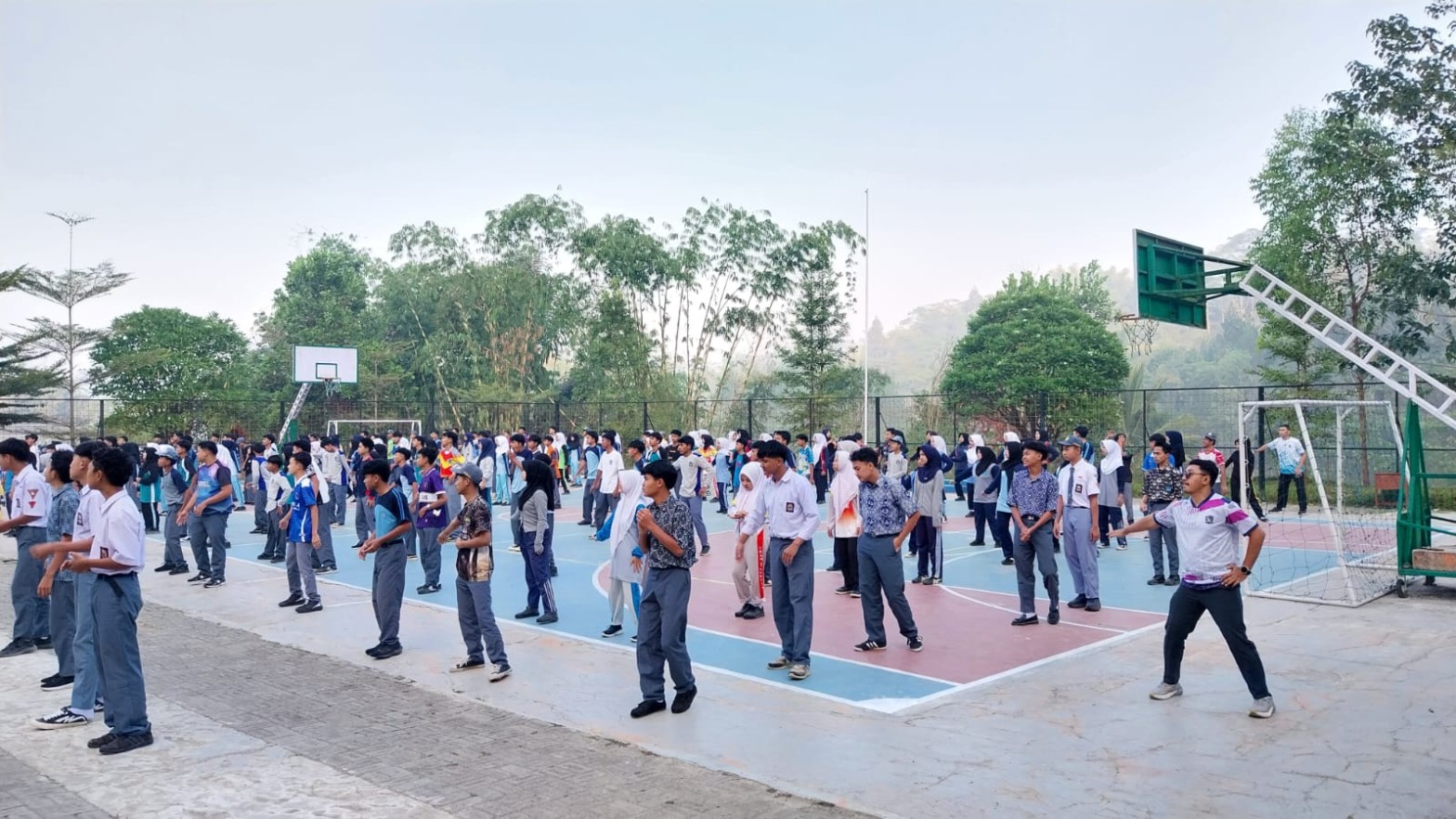 Siswa SMKN 1 Rongga berbaris rapi di lapangan basket mengikuti gerakan senam pagi dengan latar pegunungan berkabut