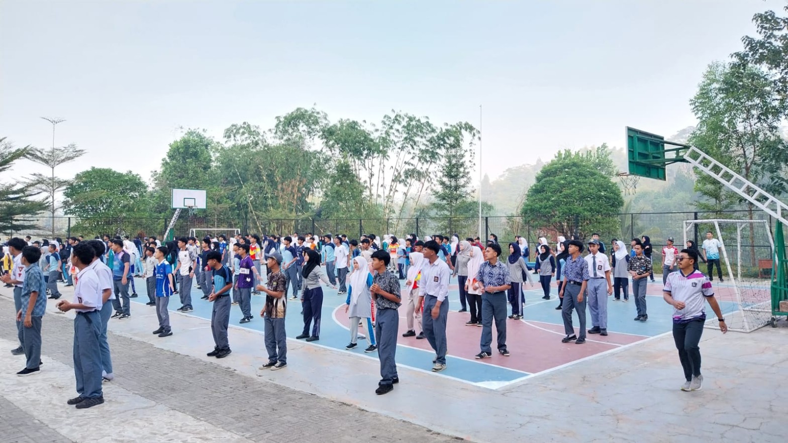 Siswa SMKN 1 Rongga mengikuti senam pagi di lapangan basket dengan latar pemandangan berkabut khas dataran tinggi