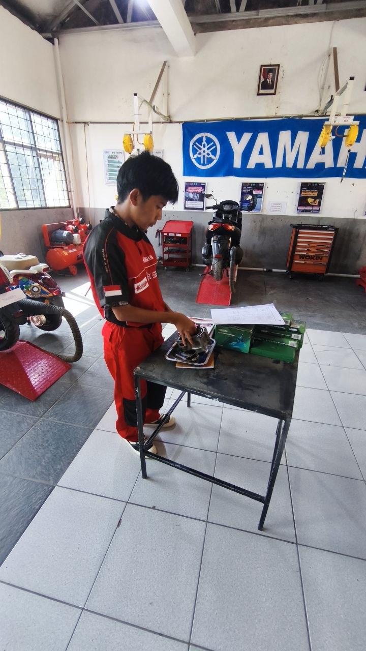 Siswa TSM SMKN 1 Rongga mengamati komponen piston di atas meja kerja dengan kotak alat ukur presisi berwarna hijau