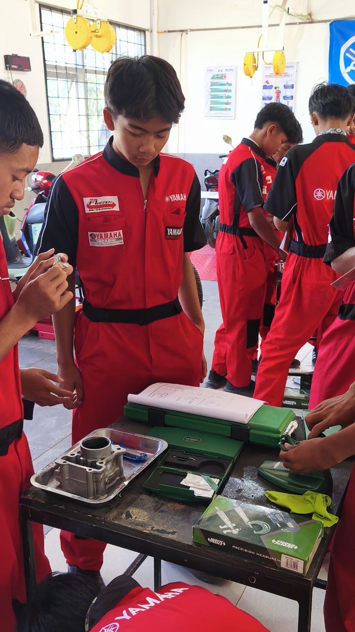 Sekelompok siswa TSM SMKN 1 Rongga mengelilingi meja kerja mengamati proses pengukuran komponen piston