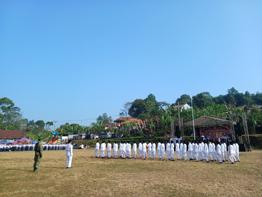Pasukan Pengibar Bendera SMKN 1 Rongga berbaris rapi dalam formasi lapangan dengan pendampingan pelatih TNI pada upacara HUT RI ke-81