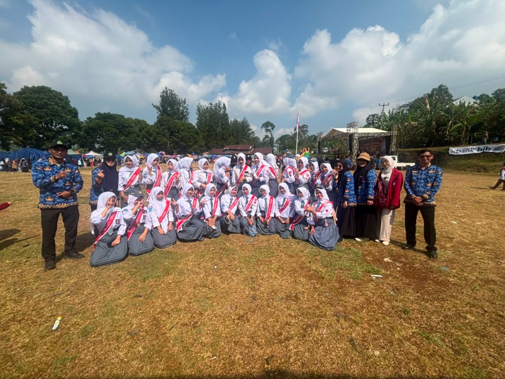 Foto bersama seluruh anggota tim Paduan Suara siswi SMKN 1 Rongga berseragam putih abu-abu dan selempang merah bersama guru pembina di tengah lapangan terbuka