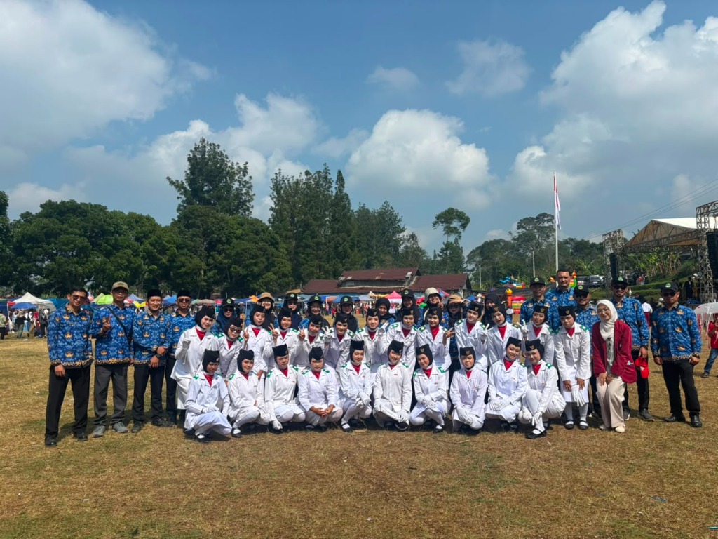 Foto bersama seluruh anggota Paskibra berseragam putih lengkap dengan peci hitam bersama dewan guru berseragam Batik KORPRI di Lapangan Rongga
