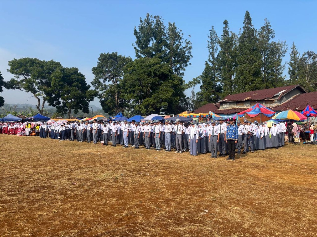Barisan panjang ratusan siswa SMKN 1 Rongga berseragam putih abu-abu membentang rapi di Lapangan Rongga dengan latar belakang perbukitan asri